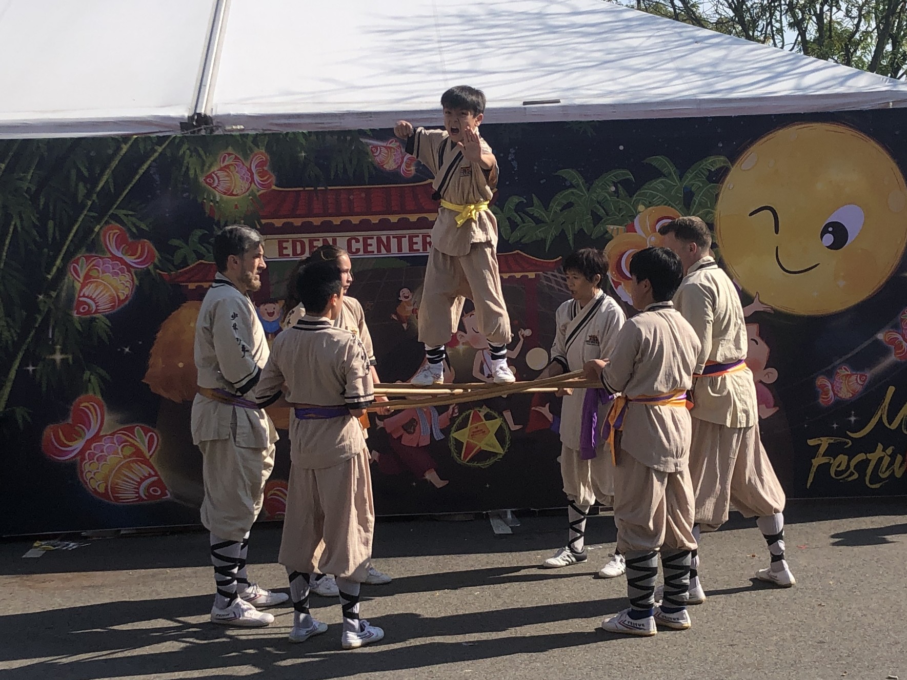 Performer standing on staffs, about to jump down